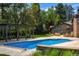 Backyard pool area with a brick pergola, treehouse, lush landscaping and the brick house at 1328 E Layton Ave, Cherry Hills Village, CO 80113