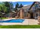 Backyard pool with brick house, manicured lawn, spiral staircase and pergola with outdoor seating at 1328 E Layton Ave, Cherry Hills Village, CO 80113