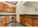 Close up view of a wet bar with granite countertops and wooden cabinets at 1328 E Layton Ave, Cherry Hills Village, CO 80113