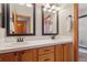 Bathroom showcasing dual sinks, wood cabinetry, and updated fixtures at 9375 S Hoyt Ct, Littleton, CO 80127