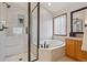 Relaxing bathroom features a soaking tub, glass-enclosed shower, and vanity at 9375 S Hoyt Ct, Littleton, CO 80127