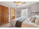Neutral bedroom with a ceiling fan, window, and a view to the en-suite bathroom at 9375 S Hoyt Ct, Littleton, CO 80127