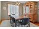 Elegant dining room with a large wooden table, modern chairs, a stylish chandelier, and a classic hutch at 9375 S Hoyt Ct, Littleton, CO 80127