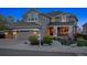 Beautiful two-story home with stone accents, a covered porch, a two-car garage, and a walkway leading to the front door at 9375 S Hoyt Ct, Littleton, CO 80127
