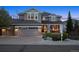 Beautiful exterior shot of home showcasing the two-car garage, stone accents, and front porch at 9375 S Hoyt Ct, Littleton, CO 80127