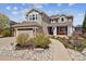 Charming two-story home with a well-manicured front yard and inviting walkway leading to the front porch at 9375 S Hoyt Ct, Littleton, CO 80127