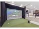 Golf simulator room complete with putting green, projector and comfortable lounge area at 9375 S Hoyt Ct, Littleton, CO 80127