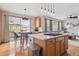 Open floorplan showing a kitchen island, eat-in table, stainless appliances and view to the living room at 9375 S Hoyt Ct, Littleton, CO 80127