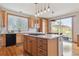 Bright kitchen featuring an island, stainless steel appliances, and hardwood floors, with a view to the backyard patio at 9375 S Hoyt Ct, Littleton, CO 80127