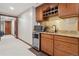 Convenient kitchenette equipped with wooden cabinetry, a microwave, and a beverage fridge at 9375 S Hoyt Ct, Littleton, CO 80127