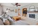 Comfortable living room with a fireplace, ceiling fan, and a view to other living spaces at 9375 S Hoyt Ct, Littleton, CO 80127