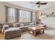 Comfortable living room with a large sectional sofa, a coffee table, big windows, and neutral carpet flooring at 9375 S Hoyt Ct, Littleton, CO 80127