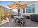 Covered patio area with an outdoor dining table, chairs, and a grill for outdoor cooking at 9375 S Hoyt Ct, Littleton, CO 80127