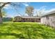 Exterior shot of the house and backyard showcasing a green lawn, patio, and detached garage at 4550 Zephyr St, Wheat Ridge, CO 80033