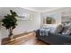 Bedroom with hardwood floors, neutral walls, a bed, and two windows with lots of natural light at 4550 Zephyr St, Wheat Ridge, CO 80033