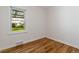 Empty bedroom with hardwood floors, white walls, base trim and natural light from a large window at 4550 Zephyr St, Wheat Ridge, CO 80033