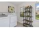 Laundry room with side-by-side washer and dryer, flower art, shelves and natural light from two windows at 4550 Zephyr St, Wheat Ridge, CO 80033