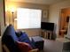 This bedroom features a futon sofa, flat screen television, and a view into the bathroom at 2240 S Pagosa Ct # B, Aurora, CO 80013