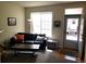 Bright living room with a door leading outside, furnished with a black leather sofa at 2240 S Pagosa Ct # B, Aurora, CO 80013