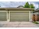 Large two car garage with concrete driveway and wooden pedestrian access to the backyard at 2479 S High St, Denver, CO 80210
