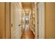 Bright hallway featuring hardwood floors, built-in shelves, and multiple closets at 2479 S High St, Denver, CO 80210