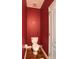 A classic-style toilet in a compact red painted bathroom at 2479 S High St, Denver, CO 80210