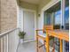 Cozy balcony features a bistro set, neutral decor and sliding glass doors to the unit at 15700 E Jamison Dr # 7-203, Englewood, CO 80112