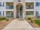 Close view of a condo entrance, showing stairs leading to upper units and well-kept grounds at 15700 E Jamison Dr # 7-203, Englewood, CO 80112