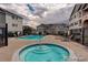 Community pool and hot tub surrounded by lounge chairs and well maintained buildings at 15700 E Jamison Dr # 7-203, Englewood, CO 80112