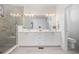 Bright bathroom featuring double vanity, quartz countertop, modern lighting, and a glass-enclosed shower at 21482 E 60Th Ave, Aurora, CO 80019