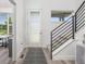Bright entryway featuring a modern door, staircase with metal railings, and wood-style flooring at 21482 E 60Th Ave, Aurora, CO 80019