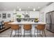 Modern kitchen featuring white cabinets, a large island with seating, and stainless steel appliances at 21482 E 60Th Ave, Aurora, CO 80019