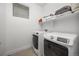 Efficient laundry room with modern washer and dryer, overhead storage shelf, and tile floor at 21482 E 60Th Ave, Aurora, CO 80019
