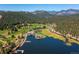 Picturesque aerial view of the golf course, lake, community center, and mountains in the background at 2397 Hearth Dr, Evergreen, CO 80439