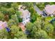 Aerial view of the home with mature trees, a large deck, and beautifully landscaped yard at 2397 Hearth Dr, Evergreen, CO 80439
