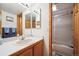 Bathroom boasts a wood vanity, framed mirror, and a convenient shower-tub combo at 2397 Hearth Dr, Evergreen, CO 80439