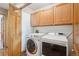 Convenient laundry room with washer, dryer, and ample cabinet space at 2397 Hearth Dr, Evergreen, CO 80439