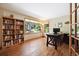 Well-lit home office with hardwood floors, built-in bookcase, and a large window at 2397 Hearth Dr, Evergreen, CO 80439