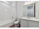 Clean bathroom with white tile surround, shower/tub combo, and modern vanity at 19100 E 96Th Pl, Commerce City, CO 80022