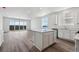 Open-concept kitchen and living area with a large island, modern appliances, and ample natural light at 19100 E 96Th Pl, Commerce City, CO 80022