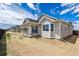 Rear exterior showcasing a patio and well-maintained yard with clear blue skies at 19100 E 96Th Pl, Commerce City, CO 80022