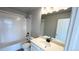 Bright bathroom featuring a shower-tub combo, quartz counters, and vanity mirror at 16830 Mckay Dr, Mead, CO 80542