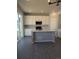 Modern kitchen featuring white cabinets, a large island, and gray flooring at 16830 Mckay Dr, Mead, CO 80542