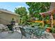 Backyard with a patio, dining table, chairs, grill and lush green trees at 675 Dahlia St, Denver, CO 80220