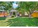 Wide backyard with patio, table, and lush landscaping with a brick house at 675 Dahlia St, Denver, CO 80220