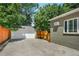 Backyard featuring a long driveway, a detached two-car garage, basketball hoop, and a wooden fence at 675 Dahlia St, Denver, CO 80220
