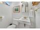 Small bathroom with a white toilet, sink, mirror and gold fixtures at 675 Dahlia St, Denver, CO 80220