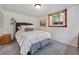 Carpeted bedroom with a queen bed, small window and wooden bedside table at 675 Dahlia St, Denver, CO 80220