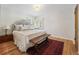 Bright bedroom with hardwood floors, a large bed, and natural light at 675 Dahlia St, Denver, CO 80220