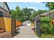 Backyard featuring a long driveway, a detached two-car garage, basketball hoop, and a wooden fence at 675 Dahlia St, Denver, CO 80220